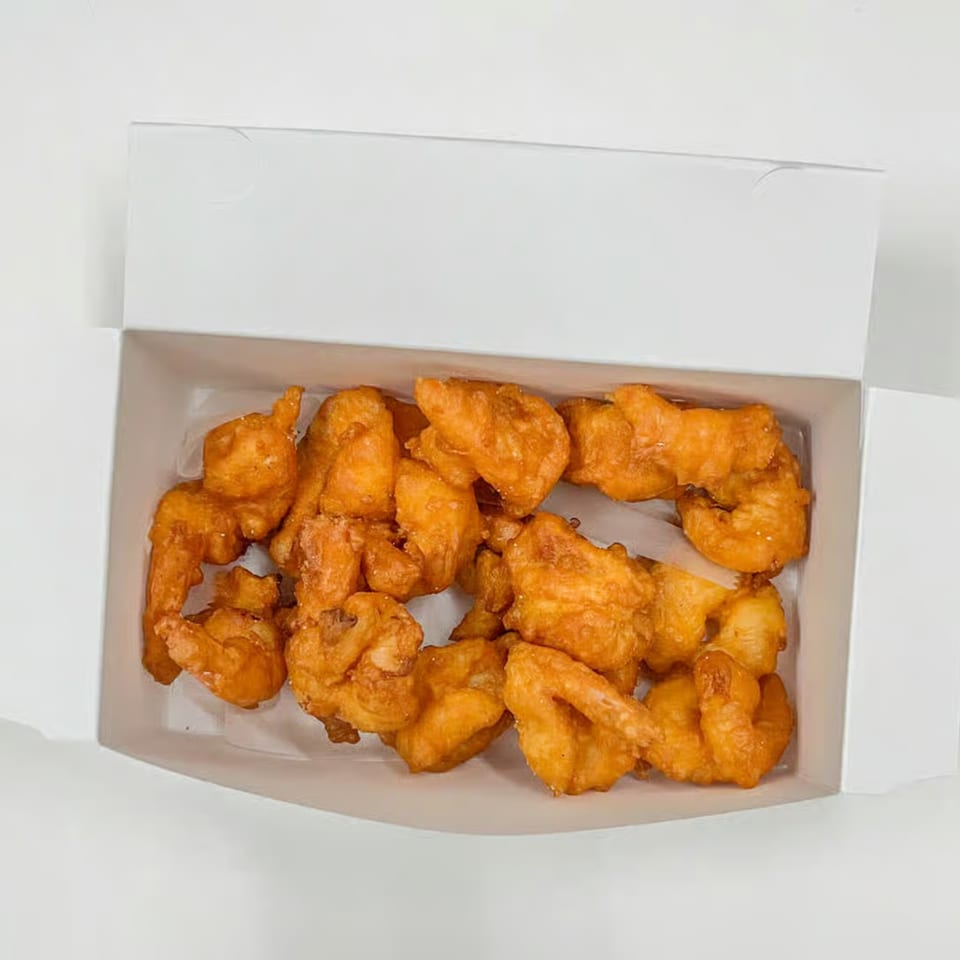 A white takeout box filled with golden-brown, crispy fried shrimp from Redford Fish & Seafood Market.